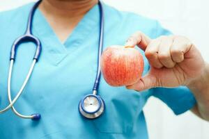 asiatisch Ernährungsberater halten Apfel gesund Essen zum geduldig im Krankenhaus, Ernährung und Vitamin. foto