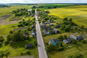 Panorama- Antenne Aussicht von Öko Dorf mit hölzern Häuser, Kies Straße, Gardens und Obstgärten foto