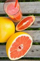 Stücke von Grapefruit und ein Glas von frisch gedrückt Grapefruit Saft.top Aussicht foto