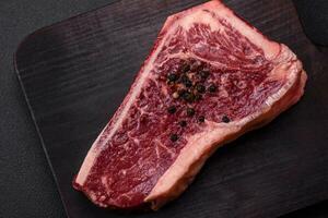 frisch saftig roh Neu York Rindfleisch Steak mit Salz, Gewürze und Kräuter foto