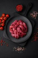 saftig roh Rindfleisch mit Gewürze, Salz- und Kräuter auf ein dunkel Beton Hintergrund foto