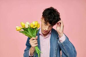 ziemlich Mann im ein Denim Jacke mit ein Strauß von Blumen ein Geschenk Romantik Urlaub unverändert foto