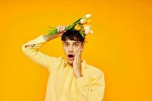 gut aussehend Kerl mit ein modisch Frisur im Gelb Hemden mit Blumen Gelb Hintergrund unverändert foto