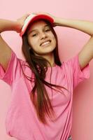 heiter jung Mädchen mit ein Deckel auf ihr Kopf im ein Rosa T-Shirt foto