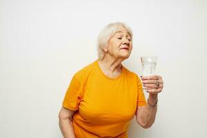 lächelnd Alten Frau halten ein Glas von Wasser Gesundheit Licht Hintergrund foto