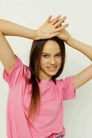 positiv Frau im ein Rosa T-Shirt beiläufig Kleider Rosa Hintergrund foto