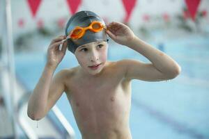 Junge im ein Schwimmen Deckel und Schwimmen Brille im das Schwimmbad. das Kind ist beschäftigt, verlobt im das Schwimmen Abschnitt. foto