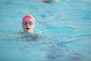 Kind Athlet schwimmt im das Schwimmbad. Schwimmen Abschnitt. foto