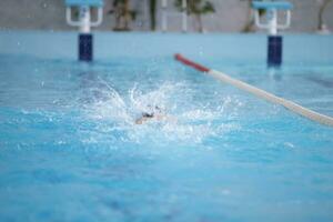 ein Athlet ist Schwimmen im das Sport Schwimmbad. foto