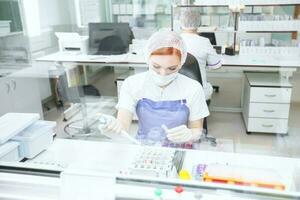 das Arzt im das medizinisch biochemisch Labor Analysen. ziemlich Labor Assistent Analysieren ein Blut Stichprobe im ein Krankenhaus. foto