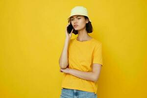 Foto ziemlich Mädchen im ein Gelb Hut Jugend Stil beiläufig reden auf das Telefon Lebensstil unverändert