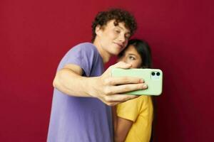 Mann und Frau im bunt T-Shirts mit ein Telefon Jugend Stil foto