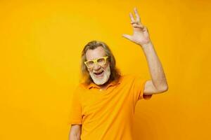 Porträt von glücklich Senior Mann Hand Gesten Emotionen Gelb Brille isoliert Hintergrund foto