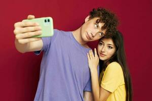 Mann und Frau im bunt T-Shirts mit ein Telefon Jugend Stil foto