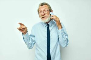 Foto von im Ruhestand alt Mann im ein Hemd mit ein Krawatte mit ein Telefon Technologie Licht Hintergrund
