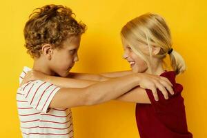 Junge und Mädchen kuscheln Mode Kindheit Unterhaltung Gelb Hintergrund foto