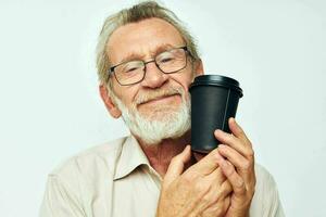 Senior grauhaarig Mann im ein Hemd und Brille ein schwarz Glas isoliert Hintergrund foto