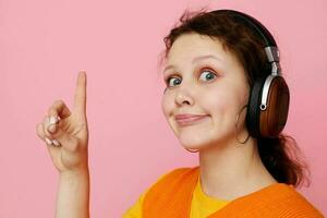 ziemlich Mädchen Hören zu Musik- mit Kopfhörer Orange Sweatshirt Emotionen Spaß abgeschnitten Aussicht unverändert foto