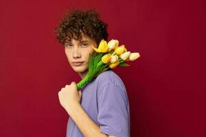 jung Kerl rot Haar im beiläufig tragen Strauß von Blumen Geschenk rot Hintergrund unverändert foto