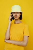 Foto ziemlich Mädchen Gelb T-Shirt und Hut Sommer- Stil mit Telefon Lebensstil unverändert