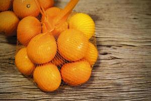 Mandarine im Paket auf Holzhintergrund mit Kopienraum foto