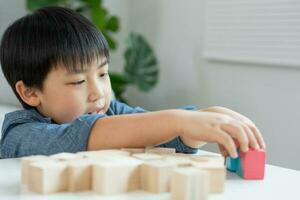 glücklich Asien Kinder abspielen und lernen Spielzeug Blöcke.Familie ist glücklich und aufgeregt im das Haus. litile Junge haben Spaß Ausgaben Zeit, Aktivität, Entwicklung, Ich, äq, Meditation, Gehirn, Muskeln, wesentlich Kompetenzen foto