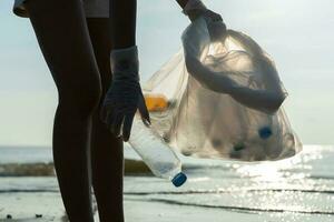 speichern Ozean. Freiwillige wählen oben Müll Müll beim das Strand und Plastik Flaschen sind schwierig zersetzen verhindern Schaden Wasser- Leben. Erde, Umfeld, Begrünung Planet, reduzieren global Erwärmen, speichern Welt foto