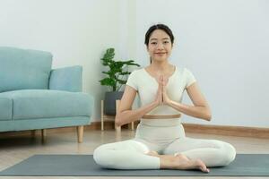 üben Yoga zusammen im Zimmer beim heim. asiatisch Frau tun Übungen im Morgen. Gleichgewicht, Meditation, Entspannung, ruhig, gut Gesundheit, Glücklich, entspannen, gesund Lebensstil, Diät, schlank foto