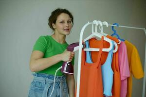 schön Frau Bügeln Kleider auf ein Aufhänger Kleiderschrank isoliert Hintergründe unverändert foto