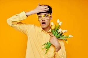 ein jung Mann mit ein Strauß von Blumen posieren ein Geschenk isoliert Hintergrund unverändert foto