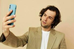 attraktiv Mann im ein passen posieren Emotionen suchen beim das Telefon isoliert Hintergrund foto