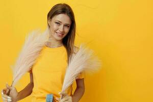 attraktiv Frau im Gelb T-Shirts, Rosa Gefieder isoliert Hintergrund foto