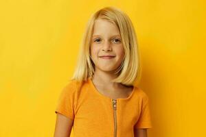 Porträt von ein wenig Mädchen im ein Gelb T-Shirt Lächeln posieren Studio Kindheit Lebensstil unverändert foto