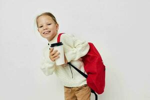 wenig Mädchen Schule Rucksack mit ein Hut auf seine Kopf isoliert Hintergrund foto