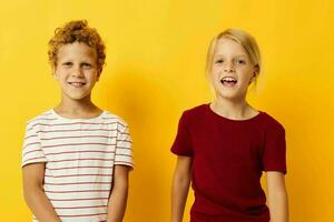 zwei froh Kinder kuscheln Mode Kindheit Unterhaltung Gelb Hintergrund foto