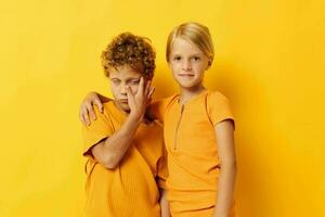 heiter Kinder im Gelb T-Shirts Stehen Seite durch Seite Kindheit Emotionen Gelb Hintergrund unverändert foto