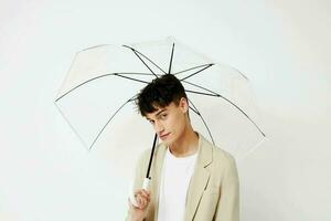 gut aussehend Kerl transparent Regenschirm ein Mann im ein Licht Jacke isoliert Hintergrund unverändert foto
