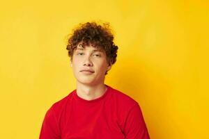 Kerl mit rot lockig Haar Emotionen rot T-Shirt Hut Studio Gelb Hintergrund unverändert foto