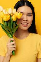 Frau im ein Gelb T-Shirt T-Shirt mit ein Strauß von Blumen Urlaub Gelb Hintergrund unverändert foto