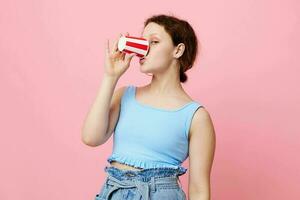 ziemlich Frau mit Einweg Glas posieren Rosa Hintergrund foto