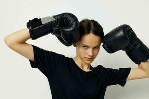 sportlich Frau im Boxen Handschuhe im schwarz Hose und ein T-Shirt Fitness Ausbildung foto