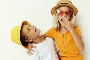 komisch Junge und Mädchen tragen Hüte posieren Mode Licht Hintergrund foto