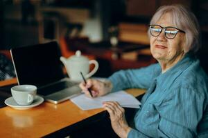 glücklich Senior Frau Unterlagen Arbeit Blatt von Papier und Stift Lebensstil unverändert foto