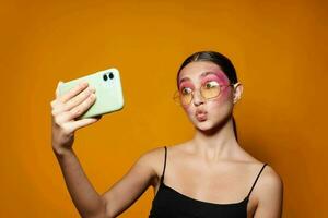 sexy Brünette Frau Lächeln hell Rosa bilden Emotionen Kosmetika Smartphone Selfie Nahansicht unverändert foto