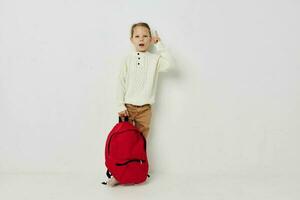 wenig Mädchen Schule rot Rucksack posieren isoliert Hintergrund foto