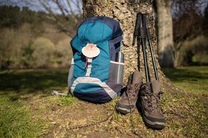 Rucksack mit Muschel, Symbol des Camino de Santiago mit Trekkingstiefeln und Stöcken