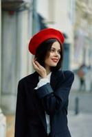 Mode Frau Lächeln Frühling Gehen im das Stadt im stilvoll Kleider mit rot Lippen und rot Baskenmütze, reisen, filmisch Farbe, retro Jahrgang Stil, städtisch Mode Lebensstil. foto