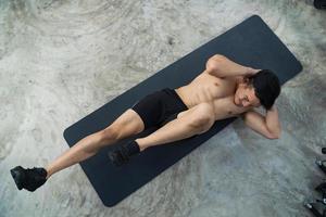 Sportlicher Mann, der Übung im Fitnessstudio trainiert foto