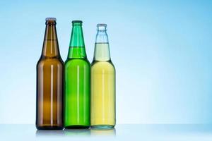 Gruppe von drei Flaschen Bier auf blauem Hintergrund