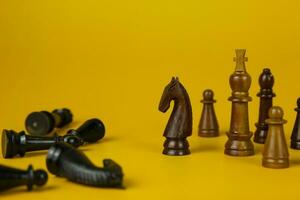 schwarz und hölzern Schach Stücke auf isoliert Gelb Hintergrund, benutzt zum Erfolg und Strategie Konzept foto